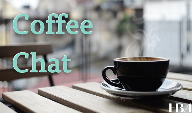 Cup of steaming coffee on a table with the text overlay of Coffee Chat